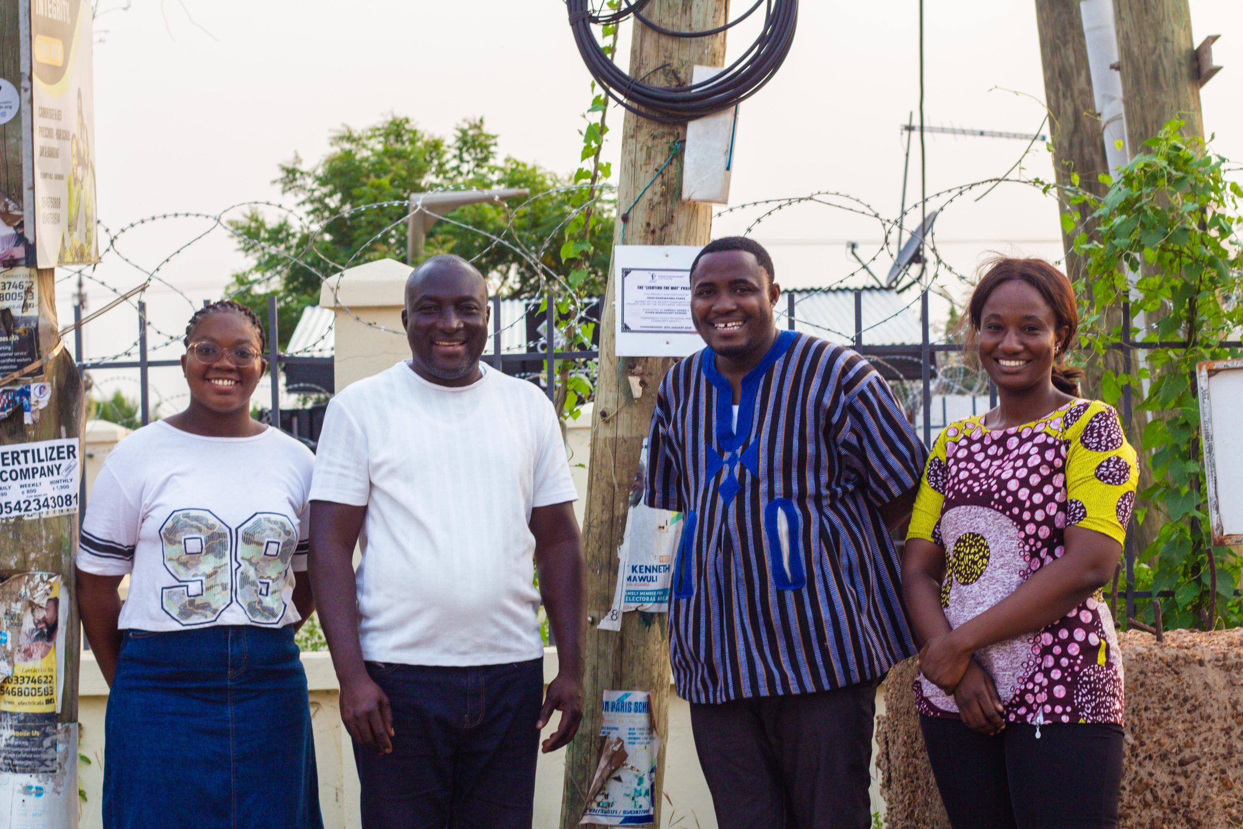 Team Kamkwamba Force beside the installed streetlight and commissioning plaque