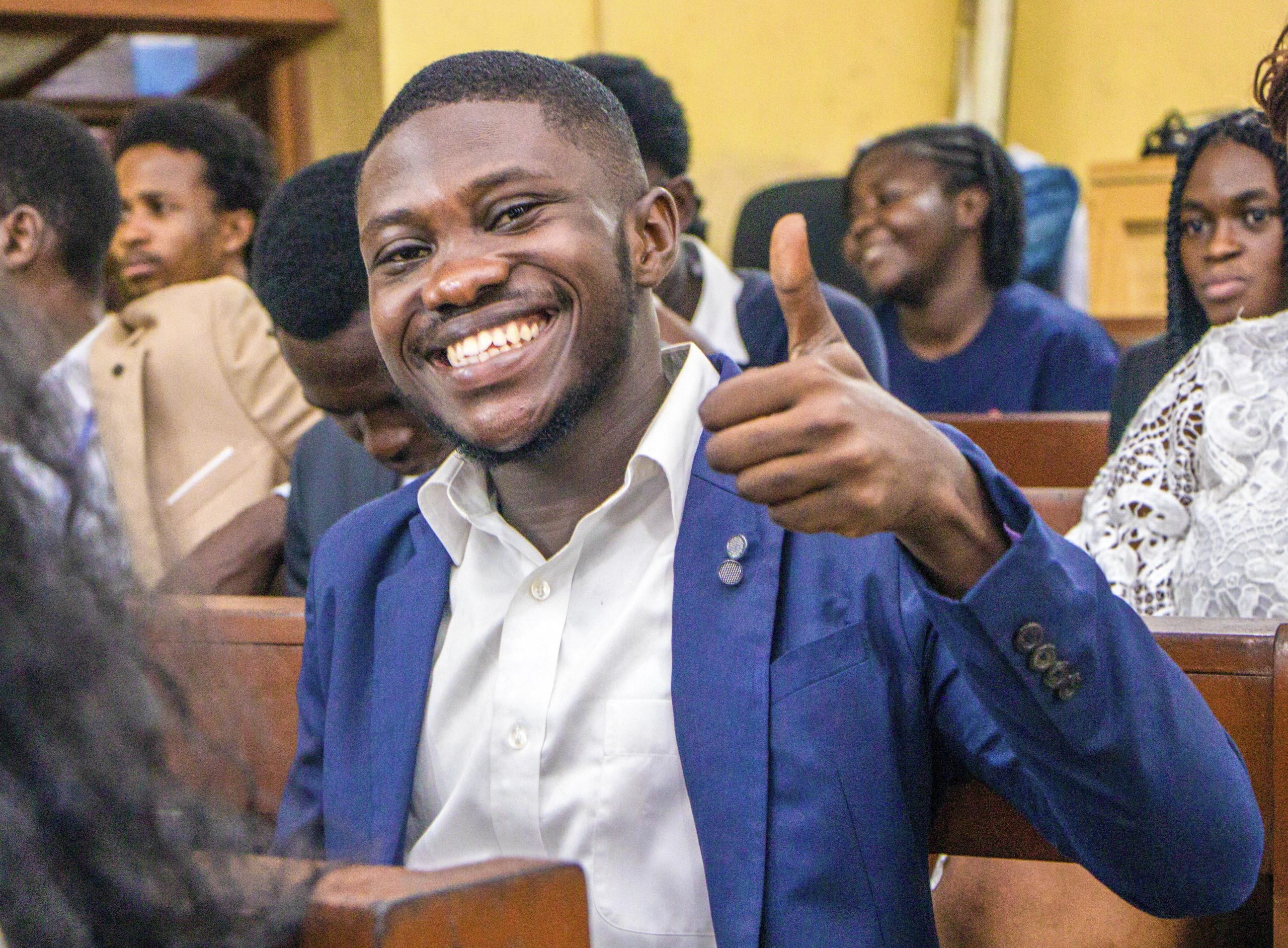 Smiling conference participant giving a thumbs up
