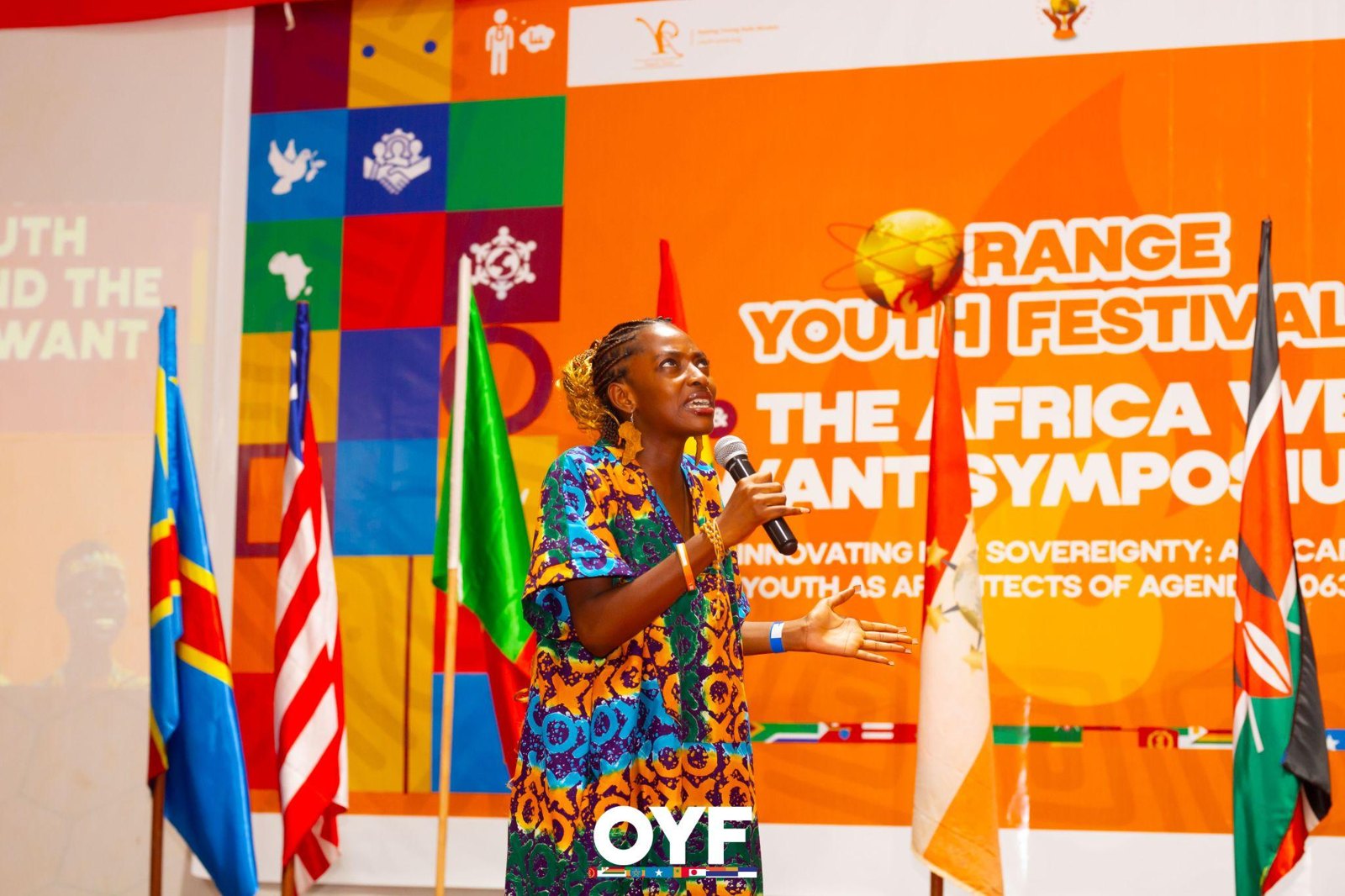 A performer holding a microphone on the Orange Youth Festival stage