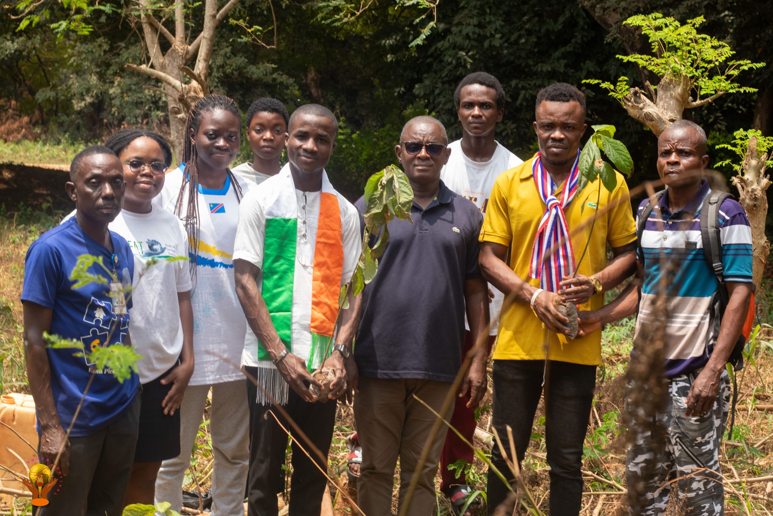 Community service participants gathered beside a planted tree